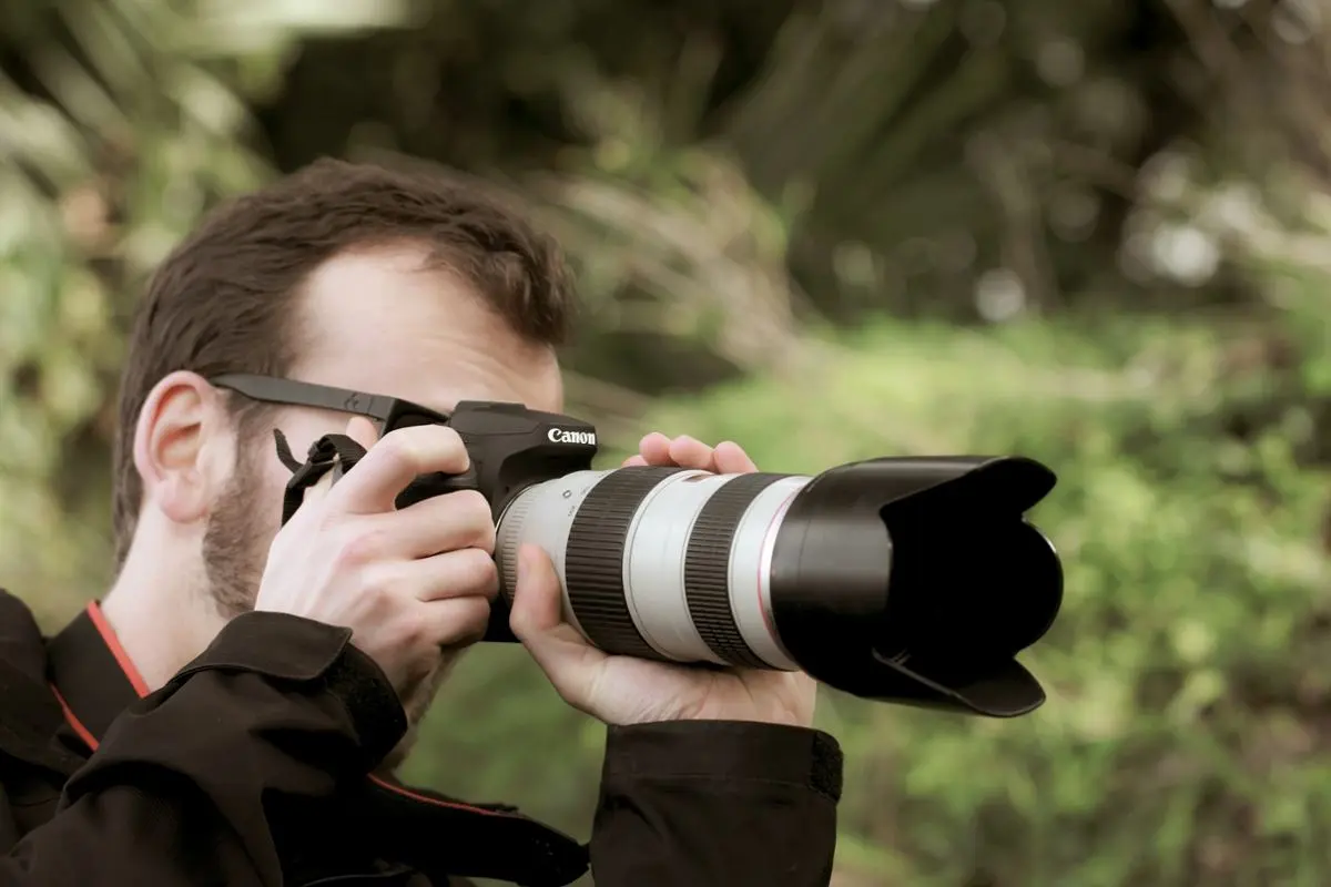 Hombre tomando fotos con cámara profesional