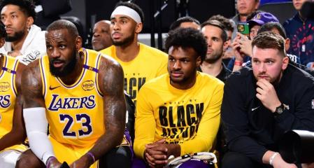 Bronny, sentado con LeBron y Doncic en un partido de esta temporada