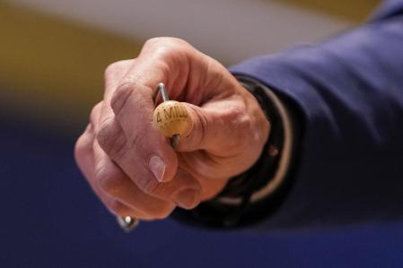 Un miembro de la Lotería muestra la bola que otorga el Gordo de la Lotería de Navidad